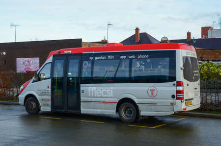 Prestatyn, UK: Dec 14, 2021: An accessible minibus parked at the bus station is being operated on behalf of TFW. It is operating a demand responsive local bus service called fflecsi.のeditorial素材