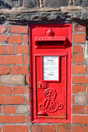 Prestatyn, UK. Jun 22, 2022. A red postbox mounted in a brick wallのeditorial素材