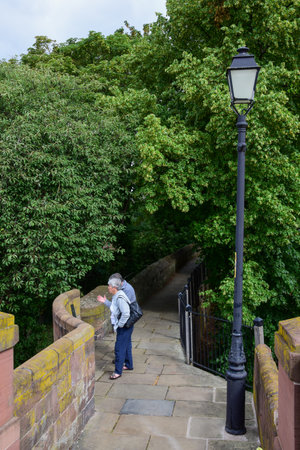 Chester, UK: Jul 3, 2022: Chester, UK: Jul 3, 2022: Tourists enjoy a walk along the Chester City Walls close to Watergateのeditorial素材