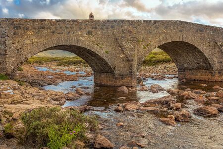 A woman on a lonely bridge in Scotland.の写真素材