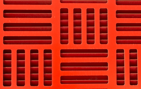 Alternating red grill pattern with visible vents and shadowsの写真素材