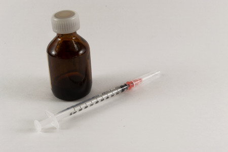 Pills tablets glass bottles and an unused medical hypodermic needleの写真素材