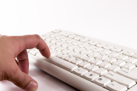 A male finger reaches to touch and press the space key on a keyboardの写真素材