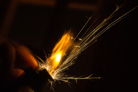 Sparks from a hand held ligther in the darkの写真素材