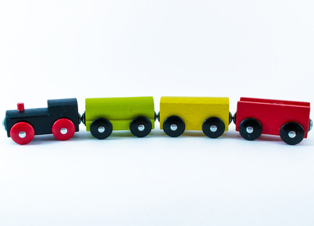 A multicolored wooden children's toy train set in red, green, black, and yellowの写真素材