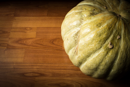A homegrown pumpkin with copyspace - set on dark wood with edgingの写真素材