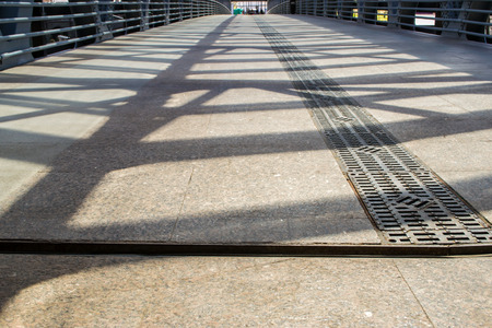 Cast Iron girders throw shadows onto a  walkway for pedestriansの写真素材