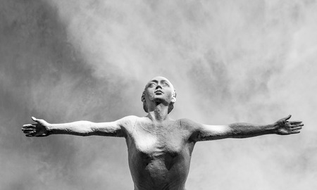 Female torso with outstretched arms reaching for the skyの写真素材