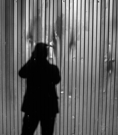 Photographer taking a photo casting shadows on a wall in black and whiteの写真素材