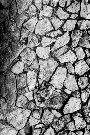 Rocks cemented in place to form a wall with signs of erosion and lichen growthの写真素材