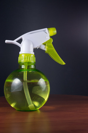 Green bottled water mister on wood with black backgroundの写真素材