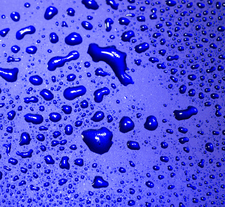 Clear water droplets reflected from bright blue tilesの写真素材