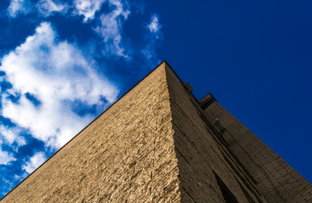 Modern skyscraper constructed with sharp edges against a cloudy skyの写真素材