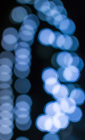 Blue bokeh blurred light effect using a black backgroundの写真素材