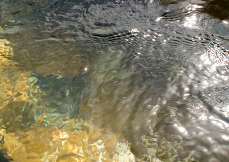 Gentle ripples from a pool of sea water catching sunlightの写真素材