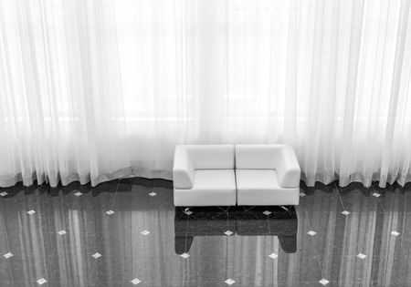 Modern sofa reflected on tiling with large curtain in black and whiteの写真素材