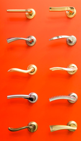 Arrangement of antique classic door handles on a red backgroundの写真素材