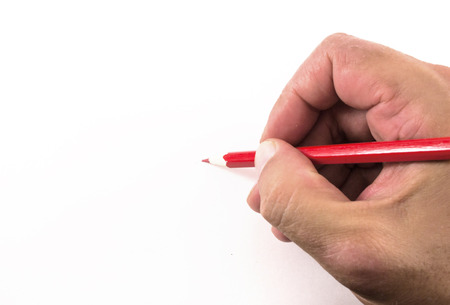 Male hand holding a red pencil drawing blank on a white backgroundの写真素材