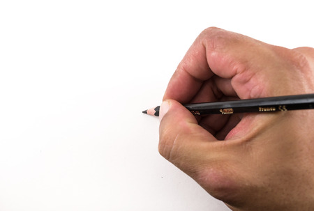 Male hand holding a black pencil drawing blank on a white backgroundの写真素材