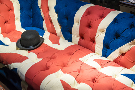British Union Jack Flag style modern cushioned sofa with black felt bowler hatの写真素材