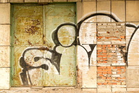 Vandal Paint graffiti on an old abandoned locked metal industrial doorwayの写真素材