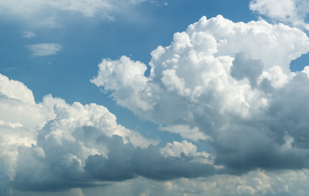 Strong white rain clouds against a blue sky with no groundの写真素材