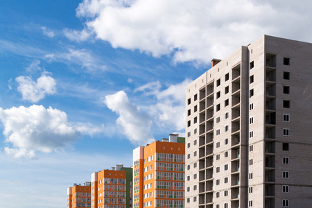 Under construction brick high-rise apartment buildings and newly painted homesの写真素材
