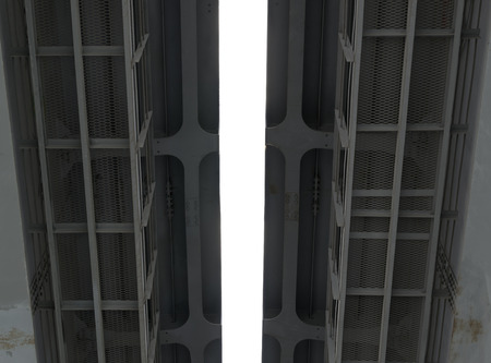 Closeup details of a metal road bridge and bright white skyの写真素材