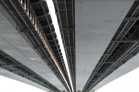Underneath view and detail of a metal road bridge and sunlightの写真素材