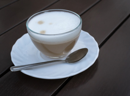 Single cup of smooth roasted coffee using a white cup on brown wood backgroundの写真素材