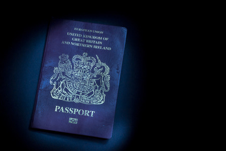Single well used United Kingdom Passport in a dark shadow backgroundの写真素材