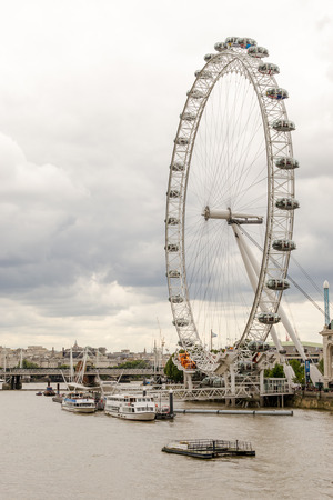 Boats sail on the River Thames past the London Eyeのeditorial素材