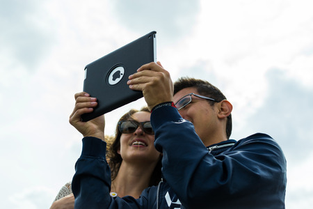 London 18th of August 2015 - Two European Tourists stop to take a selfie using their new Apple iPad...