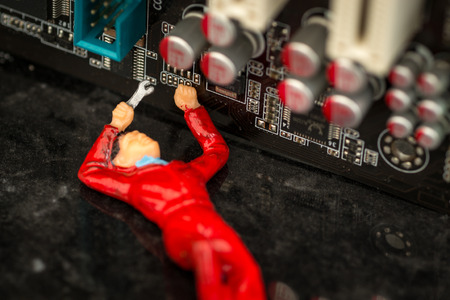 Technical Workman miniature toy works on fixing a broken home computer PC or notebookの写真素材