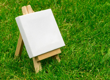 Close up of a wooden miniature model artists easel on grass with copyspace area and design spaceの写真素材