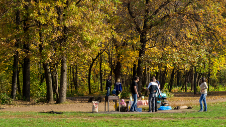 25/09 - Russian group of teenagers prepares a shashlik BBQ in a park in Autumn during 2015 in Ufa, Russiaのeditorial素材