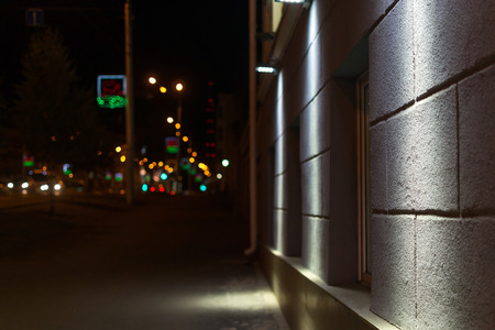 City sidewalk at night with defocused strrt lights and car headlampsの写真素材