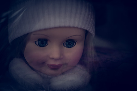 Closeup photograph of a single childs 's dolls face with nobody in the backgroundの写真素材