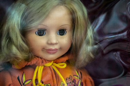 Closeup photograph of a single childs 's dolls face with nobody in the backgroundの写真素材