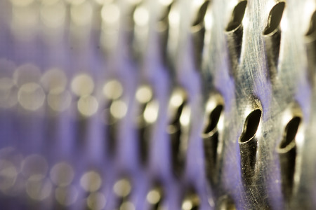 Close-up macro shot of a worn and used metal kitchen cheese or food graterの写真素材