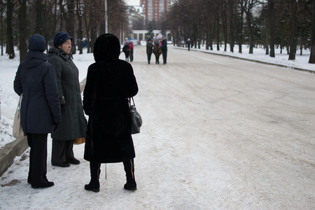UFA, RUSSIA - NOVEMBER 13, 2015: Women wait in the snow at a local park dressed in fur coats and warm winter clothing in Ufa, Russia during November of 2015のeditorial素材