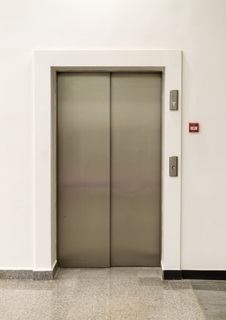 Everyday light entrance with closed metal doors allowing people to move from floor-to-floor
