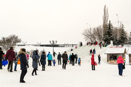 UFA - RUSSIA 19TH DECEMBER 2015 - Russian families enjoy using outdoor ice slides and winter themed...