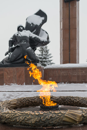 UFA - RUSSIA 16TH JANUARY 2016 - The eternal flame of remembrance burns in ?Victory Park? as a fallen soldier statue marks the heroes of the Great Patriotic War in Ufa, Russia in 2016のeditorial素材