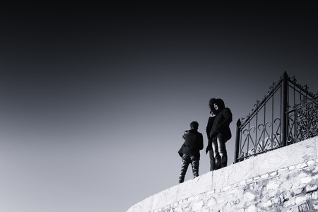 Group of three young men posing for an image by using a selfie stick. The isolation of the men in the surreal environment adds to the overall abstract qualities of the black and white image.の写真素材