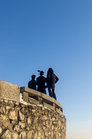 Group of three young men posing for an image by using a selfie stick. The isolation of the men in the surreal environment adds to the overall abstract qualities of the colour image.の写真素材