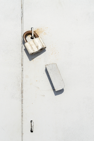 Large industrial sized sealed padlock on grey paint and steel plating with copy space areaの写真素材