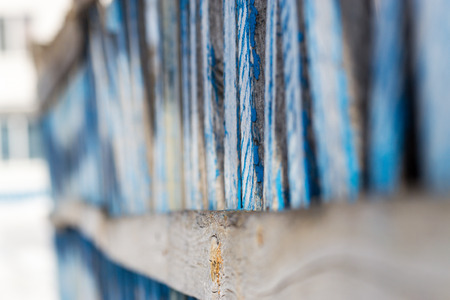 Old blue wooden fence with shallow depth of field leading off into the distanceの写真素材