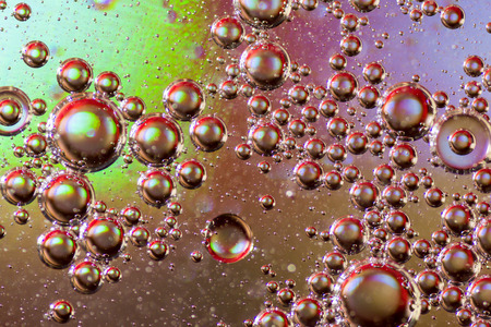 Vibrant multi-coloured bubbles form a psychedelic oil on water abstract background for modern unique...