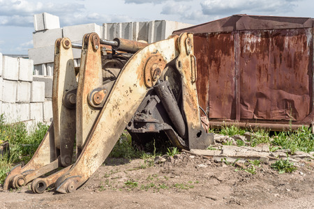 Broken and salvaged large yellow industrial machine mechanical grab frontloader at a scrap breakers...
